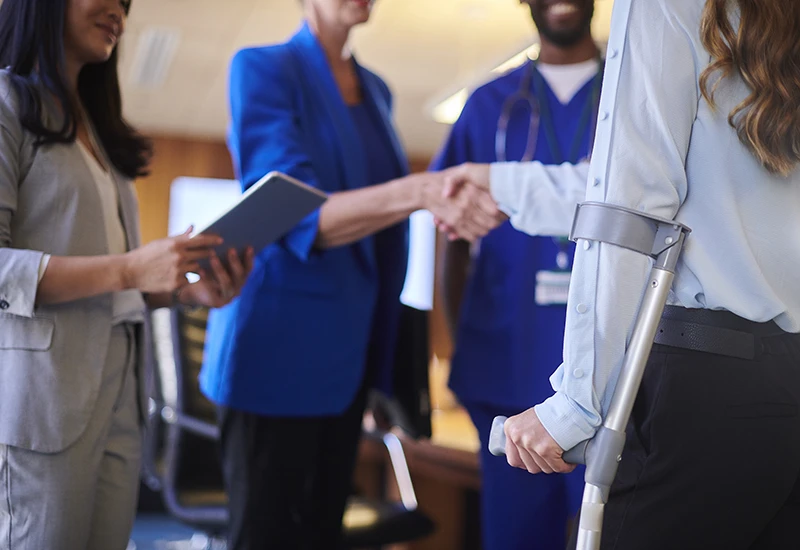 Injured worker shakes hands with a lawyer at a deposition