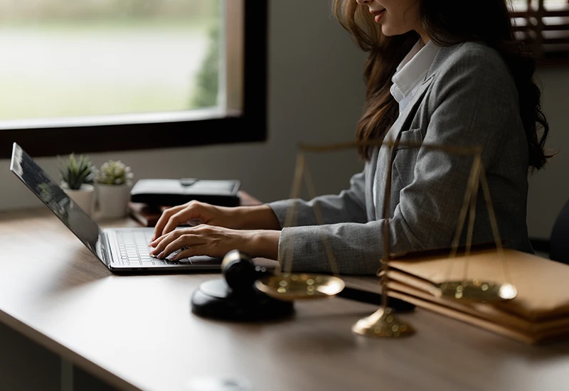 A legal transcriptionist working on a laptop in her office